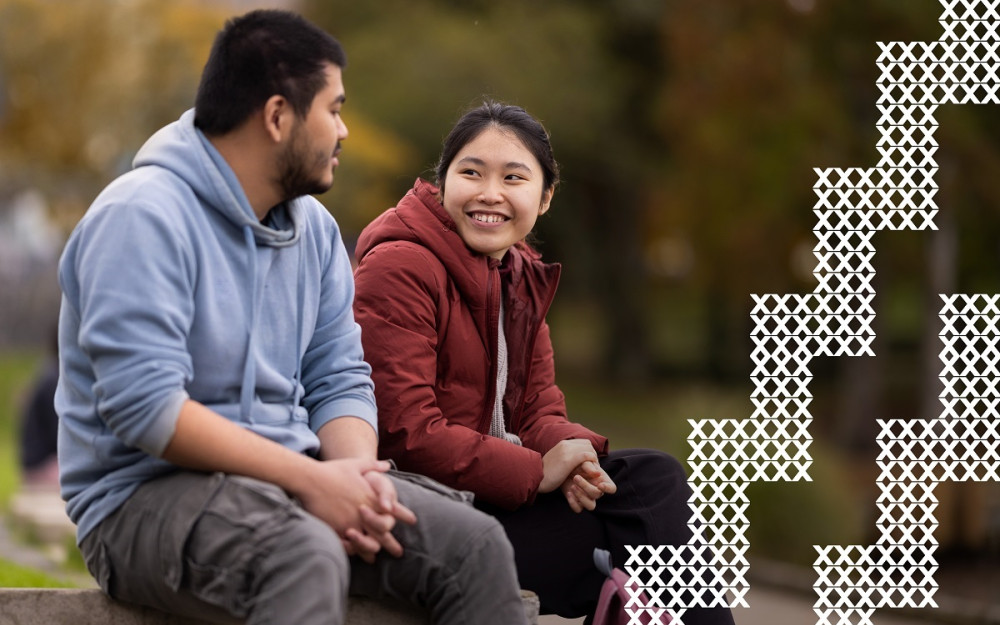 Two international students smile at each other
