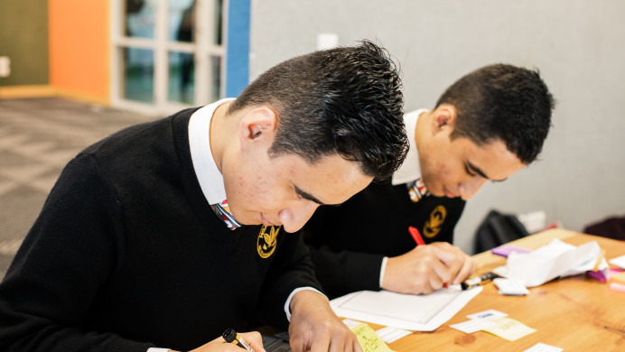 Two rangatahi at a table