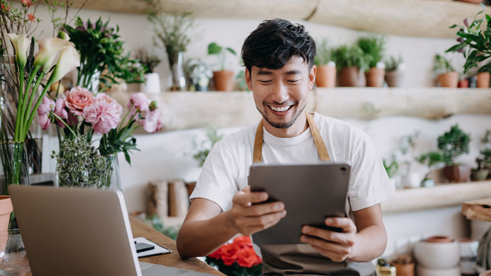 Man is checking tablet in a florists